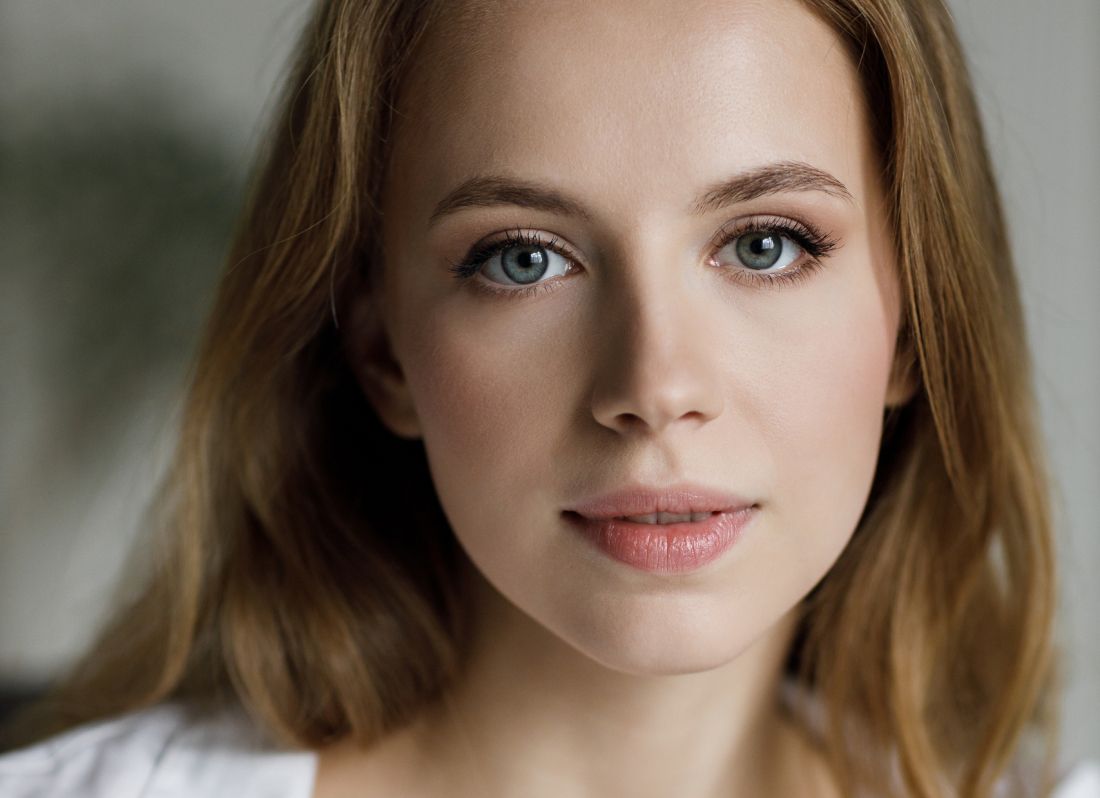 Close-up of a woman's face with blue eyes.