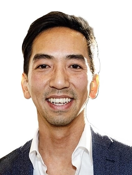 Smiling man in a suit against white background.